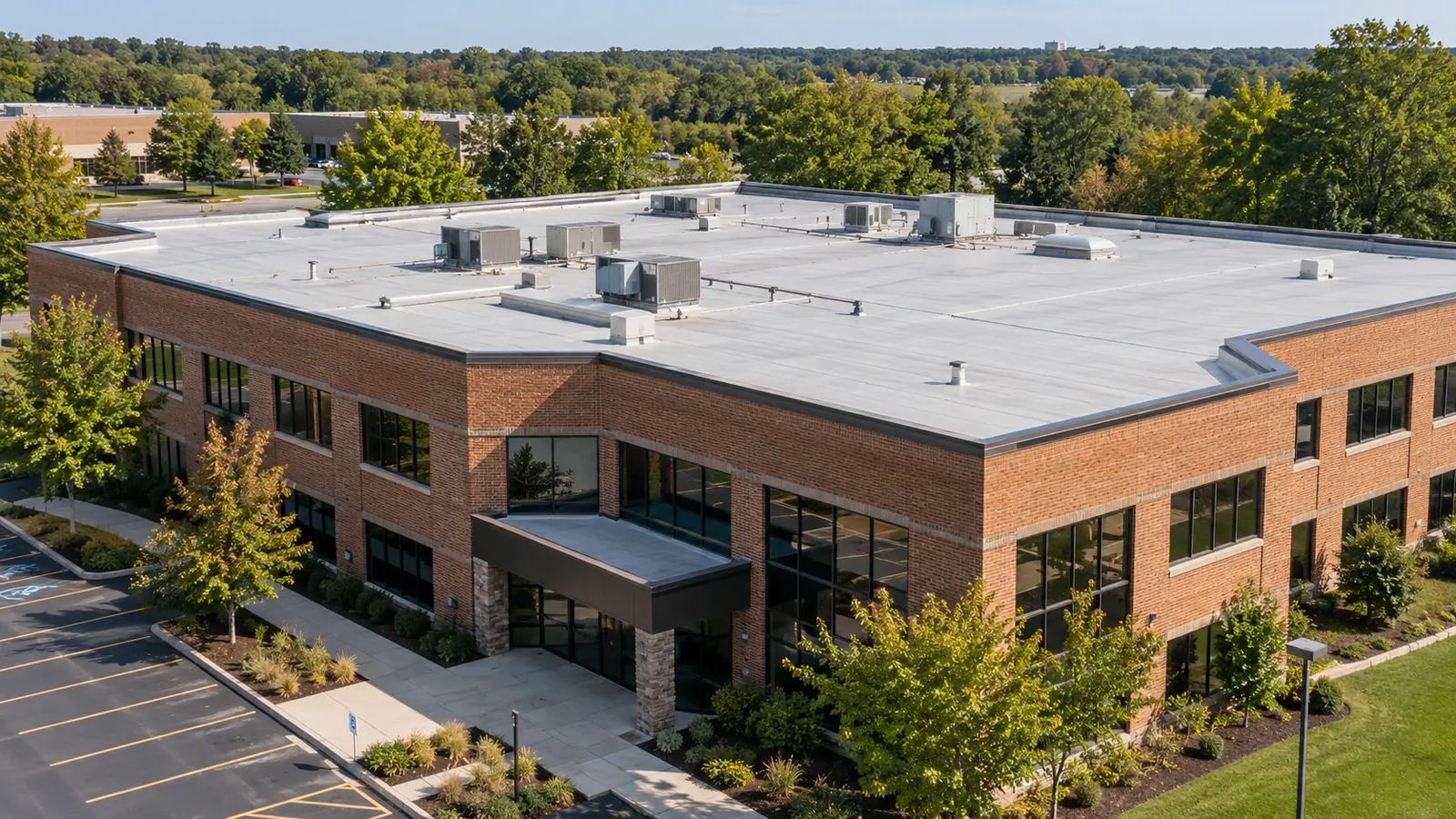Brick commercial building with a light-gray flat membrane roof and parking lot